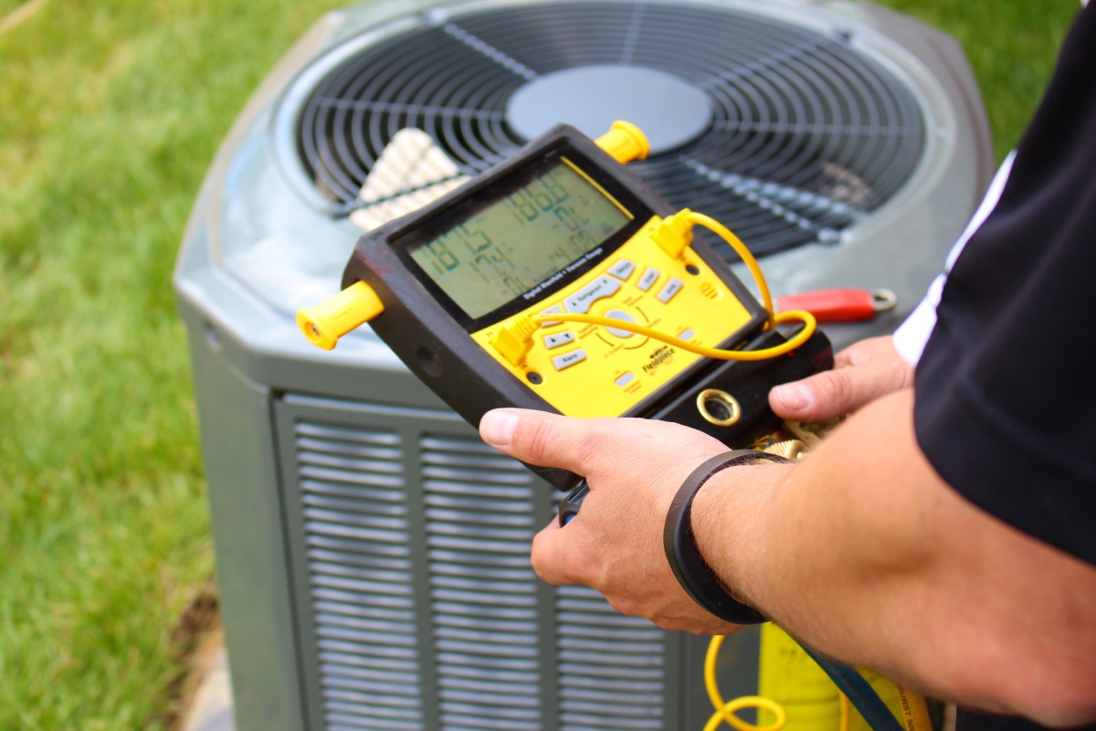 Close view of a technician checking the electrical pulse of a residential HVAC system