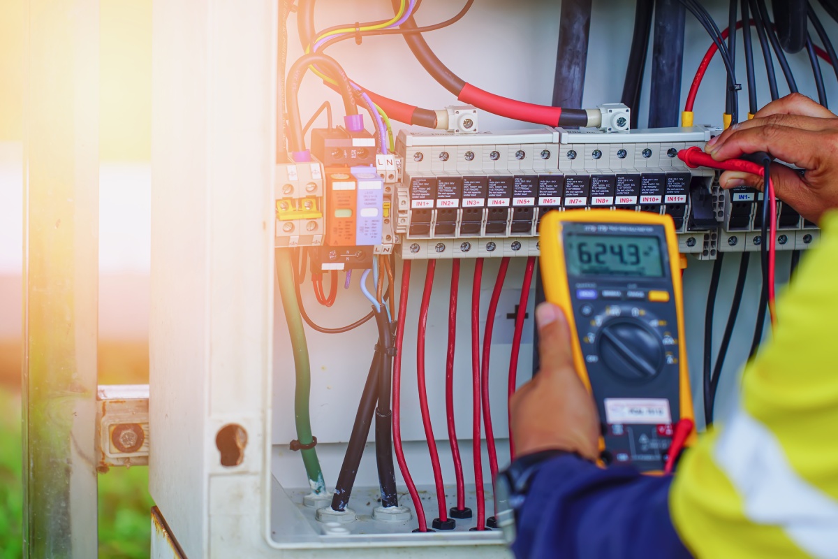 View of a technician checking the electrical charge in a fuse box